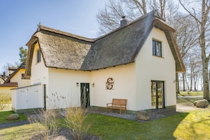 A house with a thatched roof, a green door, and a bench in the front yard. - "Ferien am Haff" Vacation Home with Sauna, Fireplace, and Terrace - Detached (Zirchow)