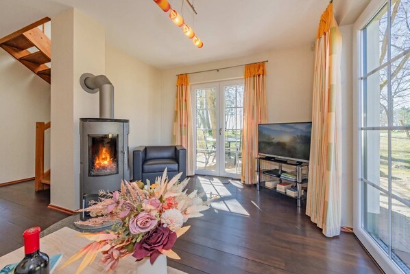 A living room with a fireplace, a television, and a large window.