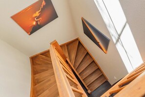 A wooden staircase with a modern light fixture and a framed picture on the wall. - "Ferien am Haff" Vacation Home with Sauna, Fireplace, and Terrace - Detached (Zirchow)