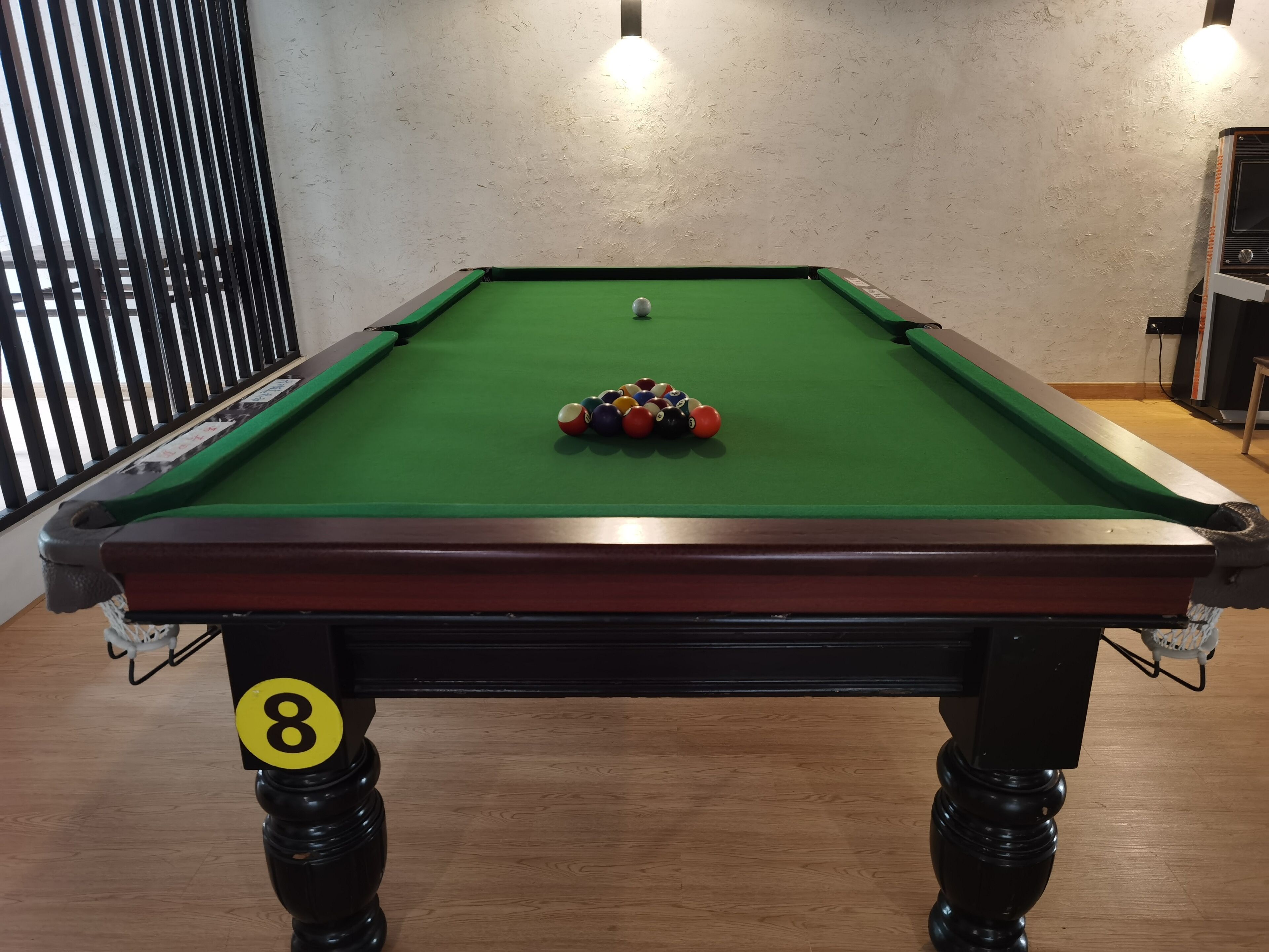 Une table de billard recouverte d’un drap vert, avec les boules numérotées de 1 à 8, et une boule blanche au centre.