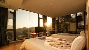 Un dormitorio con una cama grande, televisión y escritorio.
