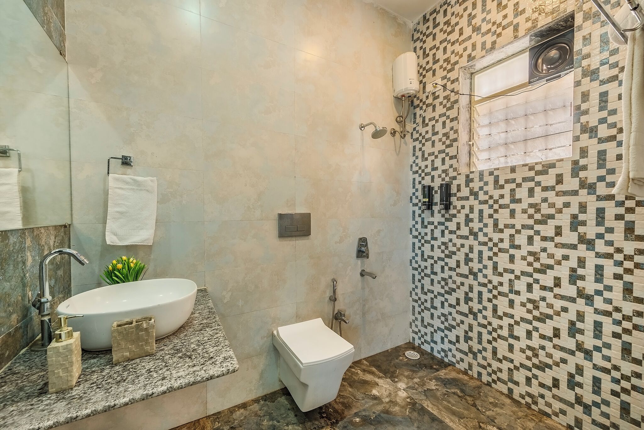 Un baño con un lavamanos blanco, inodoro y zona de ducha.