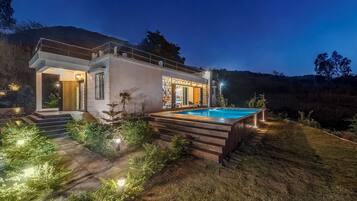 Vista frontal de la propiedad por la tarde o noche