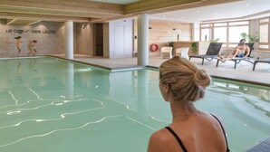A swimming pool area with a wooden wall and a sign reading "Le coeur des Loges".