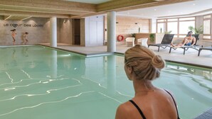A swimming pool area with a wooden wall and a sign reading "Le coeur des Loges".