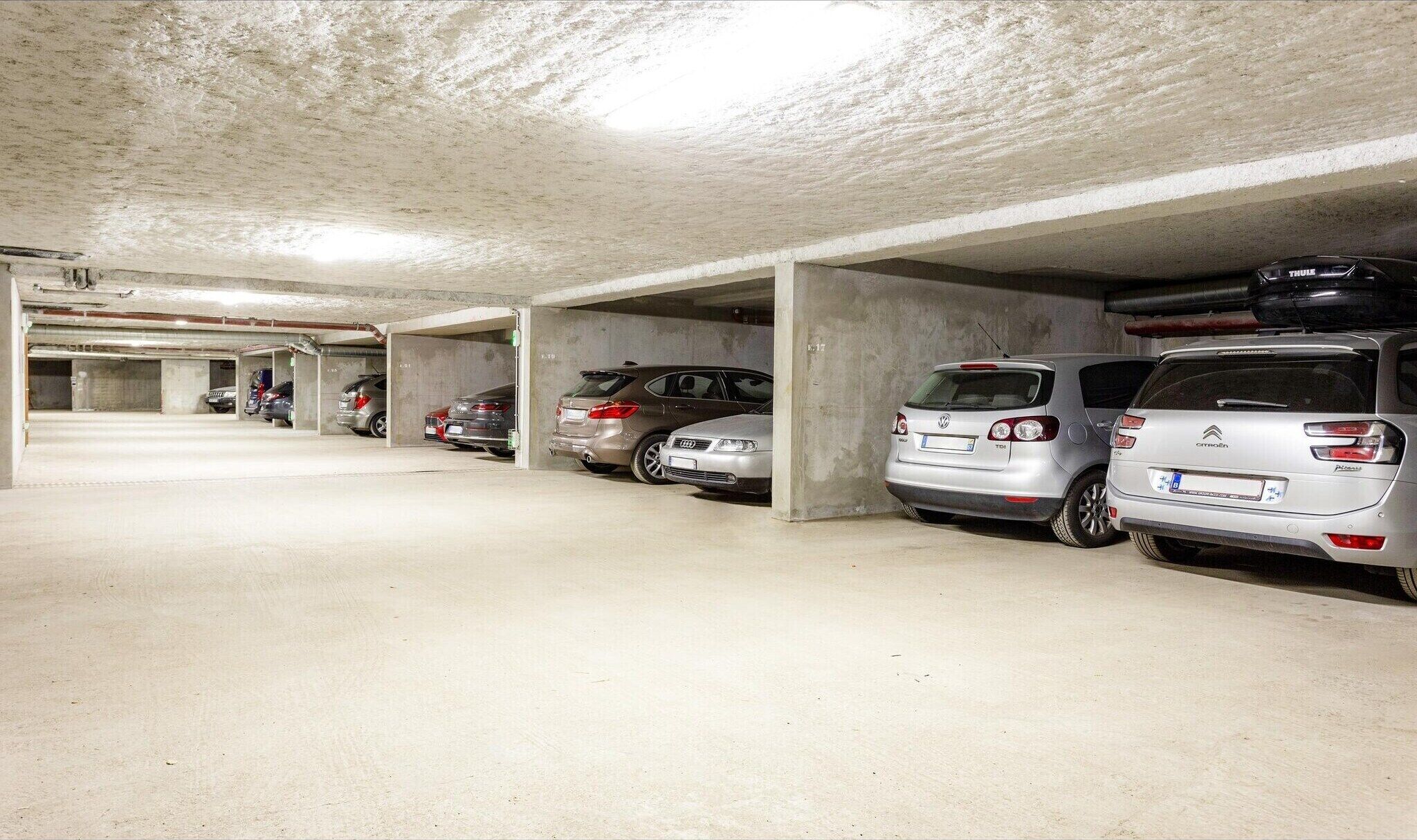 Un parking à plusieurs niveaux, doté de piliers en béton et offrant un environnement propre et bien éclairé.