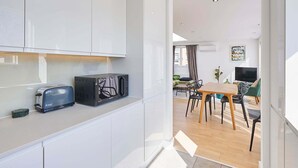 Eine moderne Küche mit weißen Schränken, einem Toaster und einer Mikrowelle.