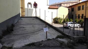 A gated hotel entrance with a chain-link fence, a no parking sign, and a sign indicating the hotel is reserved.