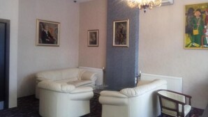 Un salon moderne avec deux canapés blancs, un fauteuil en bois et un lustre.