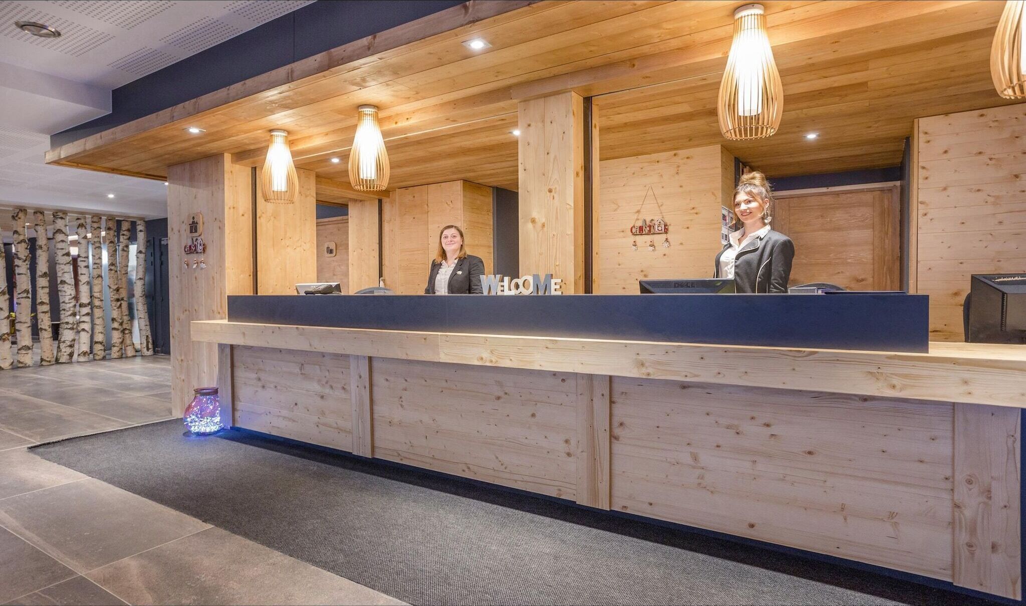 Una recepción con paneles de madera e iluminación colgante moderna.