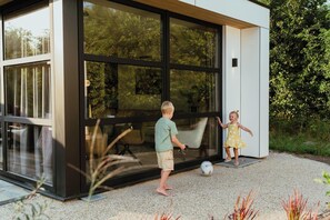 Terrace/patio - Luxurious and sustainable 4-person holiday villas with high windows, completely gas-free and equipped with solar panels. Enjoy a stylish living room, luxury kitchen, two comfortable bedrooms and a spacious bathroom with rain shower. Including made be (Vogelenzang)