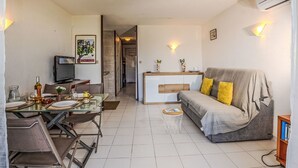 A compact living space with a dining area, a sofa, and a kitchenette.