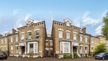 A symmetrical townhouse with a central entrance, large windows, and a brick facade.