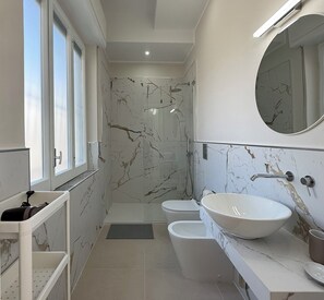 Een douche, een haardroger, een bidet, handdoeken