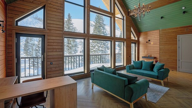 A spacious room with large windows, a wooden ceiling, and a green wall. - Park-Hotel Zarechye  (Bystrukha)