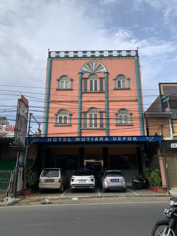 A building with a sign reading "HOTEL MUTIARA DEPOK" and multiple parked cars in front. - Hotel O Depok near Bhayangkara BRIMOB Hospital Formerly Hotel Mutiara Kelapa Dua Depok (Depok)