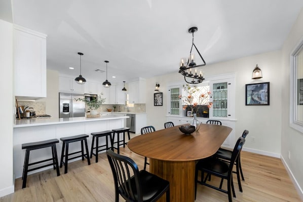 A modern kitchen with white cabinetry, a central island, and pendant lighting.