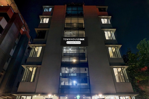 Un edificio de varios pisos con un cartel que dice 'TOWNHOUSE OAK' y 'Company Serviced'.
