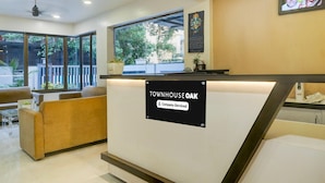 Un espace d’accueil avec une enseigne indiquant « Townhouse Oak » et une étiquette indiquant que l’établissement est géré par une entreprise.