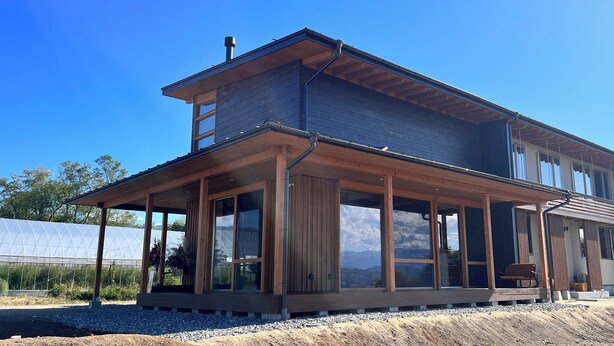 A two-story house with a covered porch, large windows, and a view of the mountains. - Cider Barn &more (Iida)