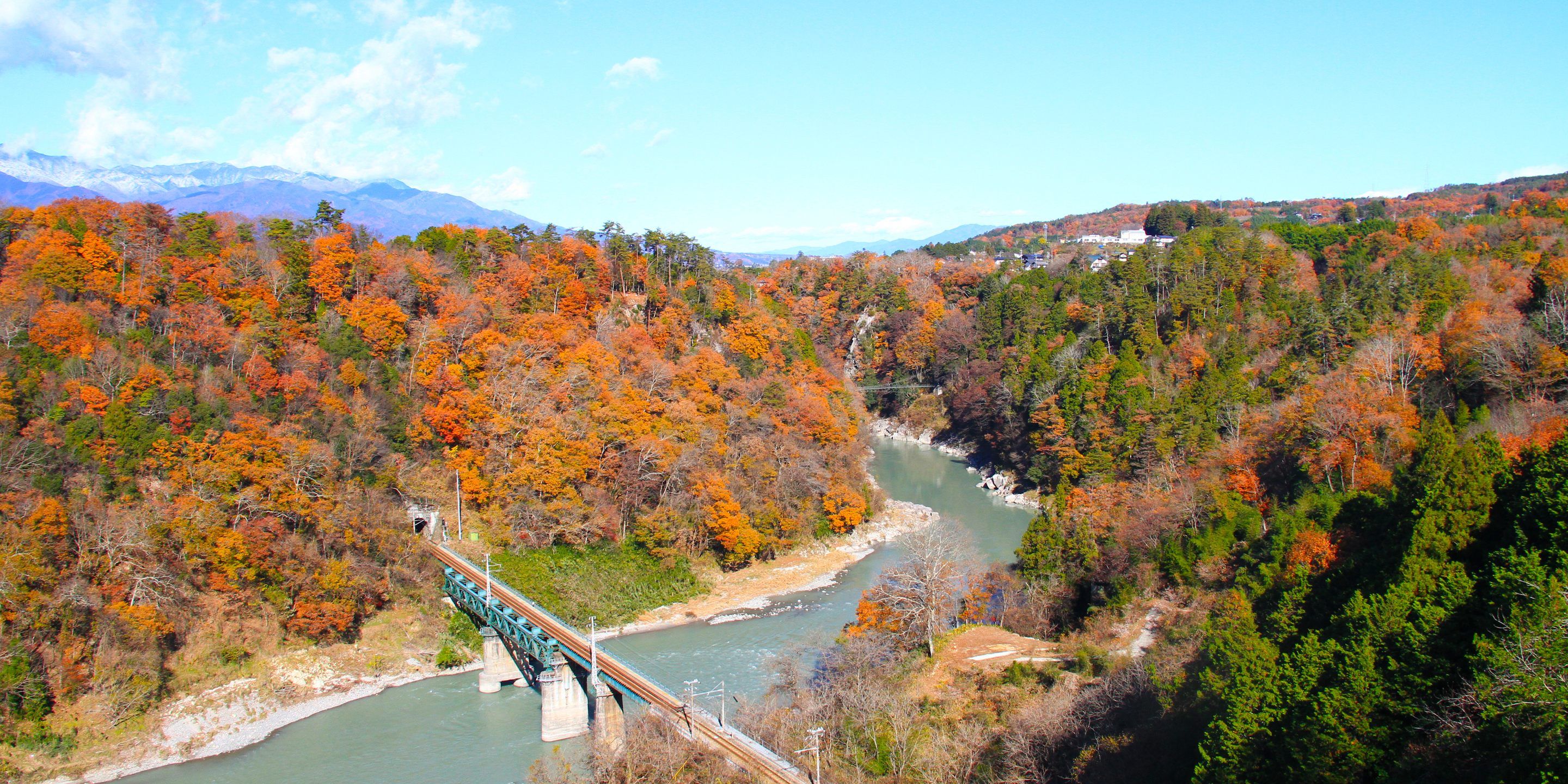 Un puente sobre un río rodeado de follaje otoñal.