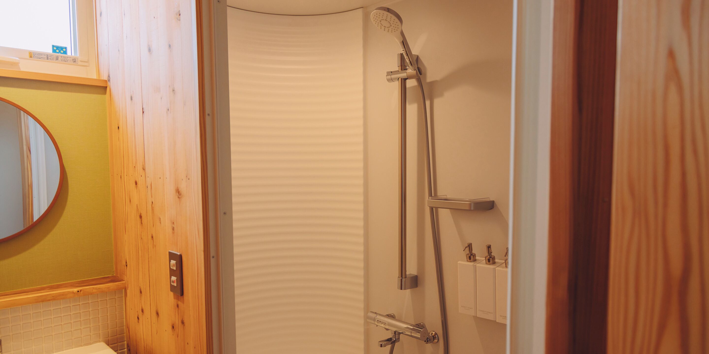 A bathroom with a wooden vanity, a shower with a handheld showerhead, and a towel rack.