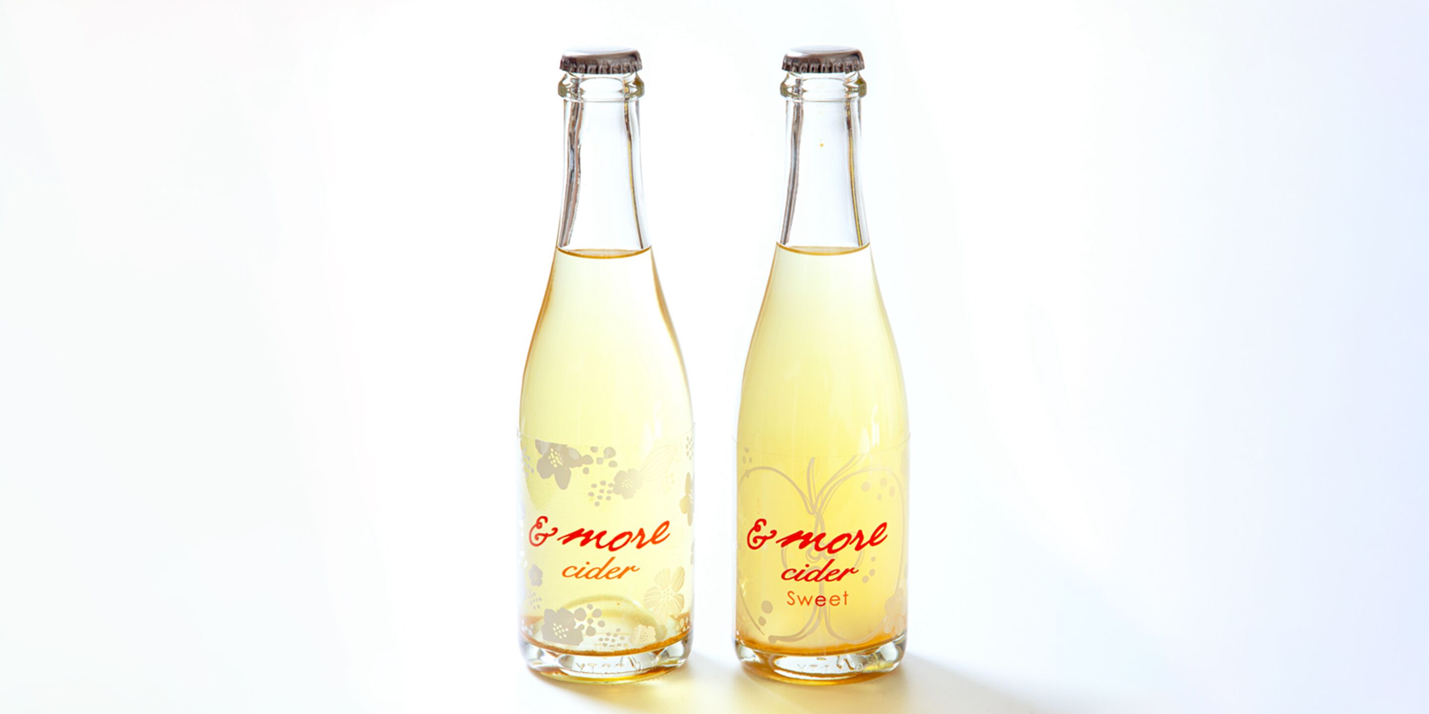 Two bottles of 'more cider' with a floral design.