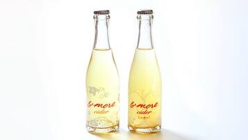 Two bottles of 'more cider' with a floral design.