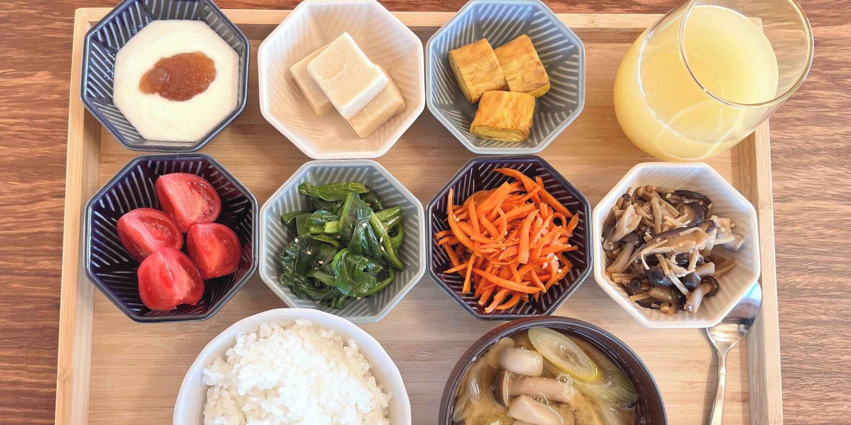 Una bandeja con diversos alimentos, como arroz, tofu y verduras.