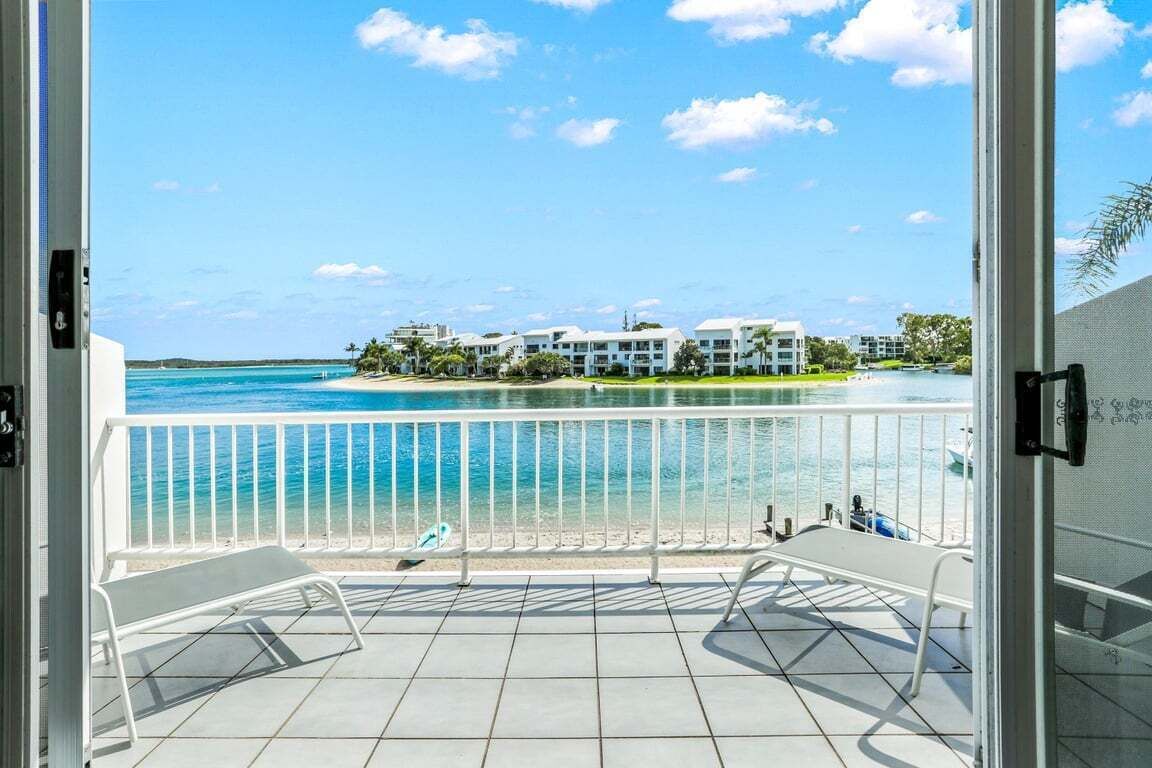 Un balcón con vistas a la playa y edificios.