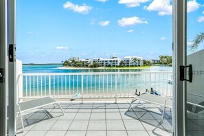 A balcony with a view of a beach and buildings.