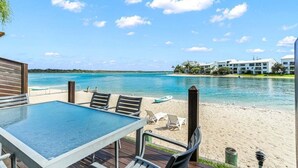 Una terraza con mesa y sillas con vista a la playa y al agua.