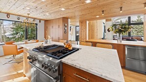 Una cocina moderna con una isla central, electrodomésticos de acero inoxidable y muebles de madera.