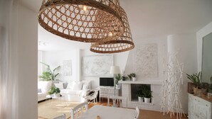 Una sala de estar moderna con un sofá blanco, una mesa de comedor y una chimenea.