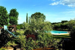 A backyard with a swimming pool, surrounded by trees and a wooden structure. - Il Pino Bioagricoltura (Terranuova Bracciolini)