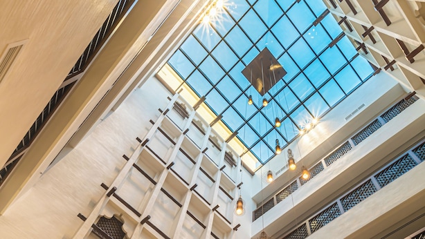 A multi-level atrium with a glass ceiling, allowing natural light to illuminate the space.