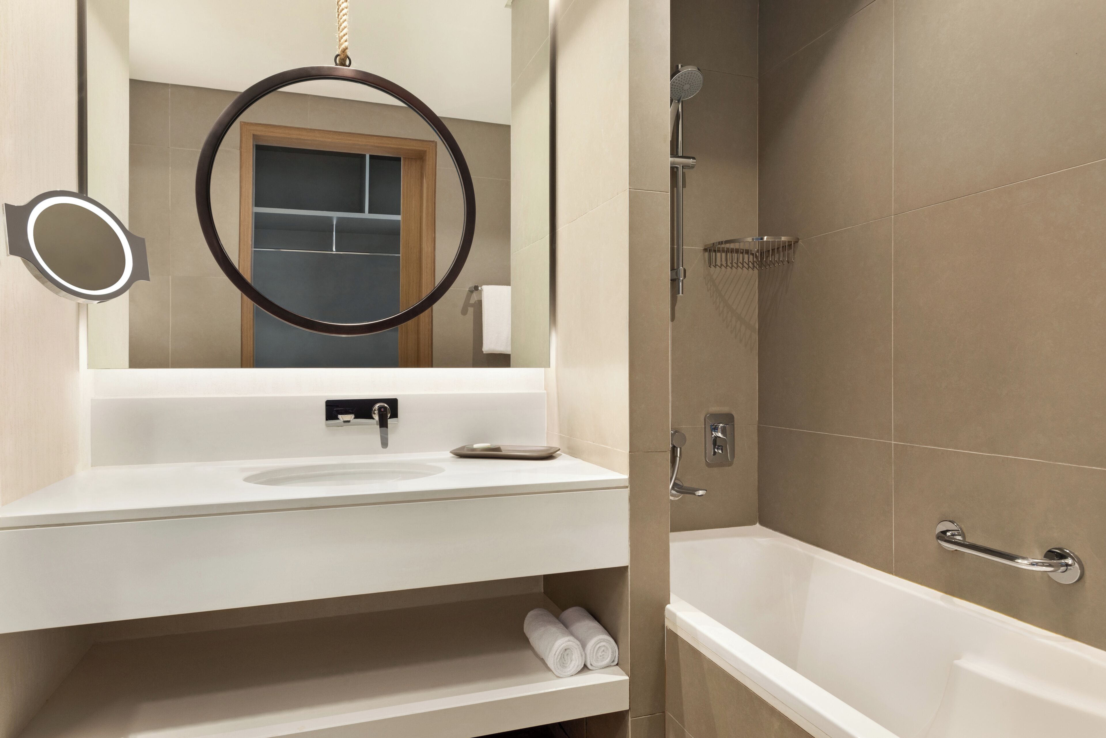 Ein modernes Badezimmer mit Waschbecken, Spiegel und Dusche.