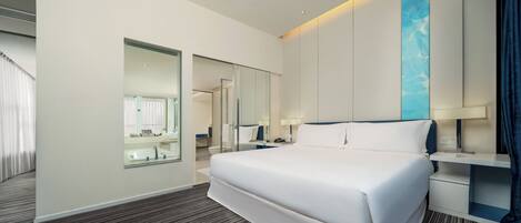Une chambre d’hôtel moderne avec un grand lit, une salle de bain avec un miroir et une vue sur la ville.
