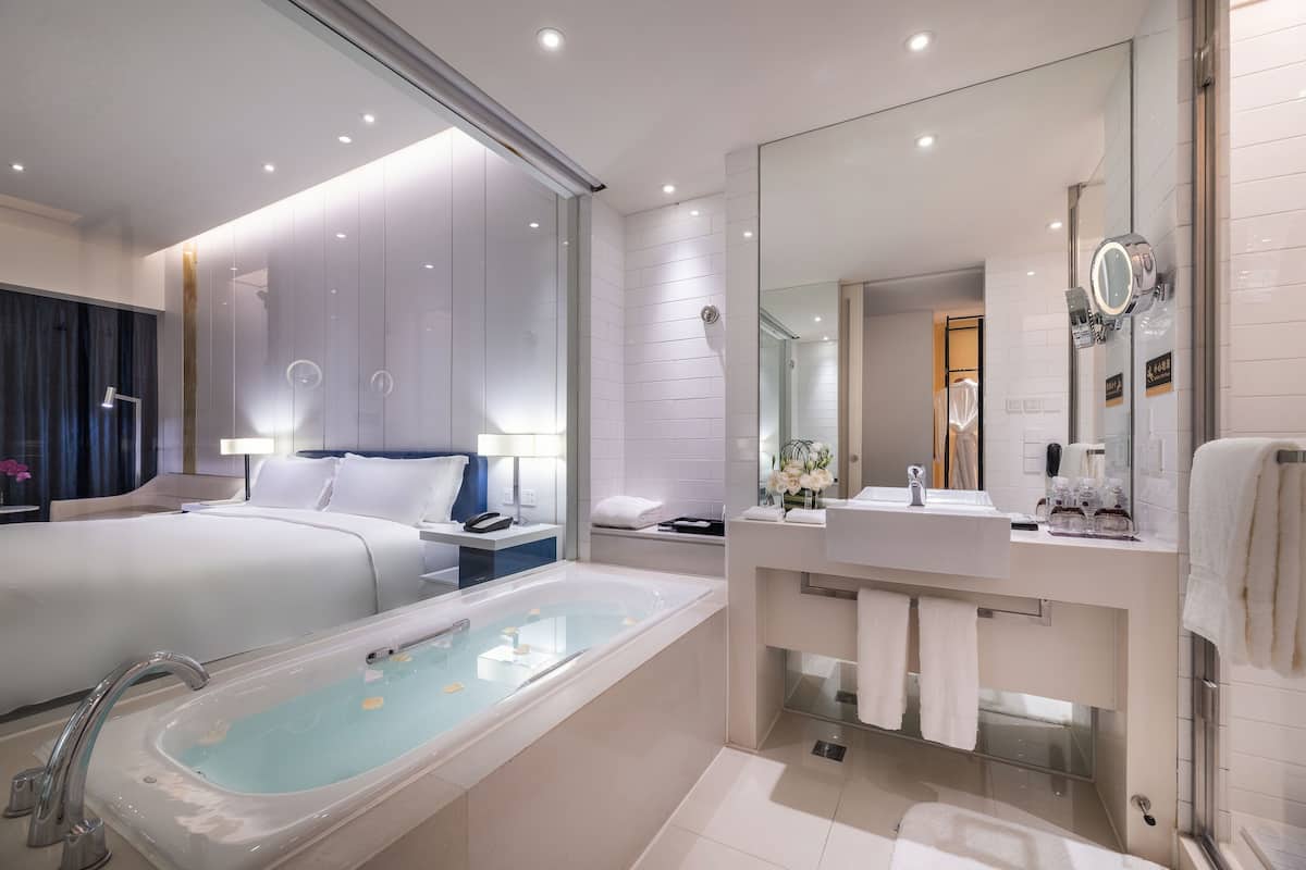 Ein modernes Badezimmer mit einer großzügigen Badewanne, einer separaten Duschkabine und einem Waschtisch mit Spiegel.
