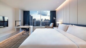 Een moderne hotelkamer met een groot bed, een bureau, een stoel en een televisie.