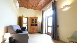 Ein Wohnzimmer mit einer Couch, einem Schrank, einer Lampe und einem Sessel.