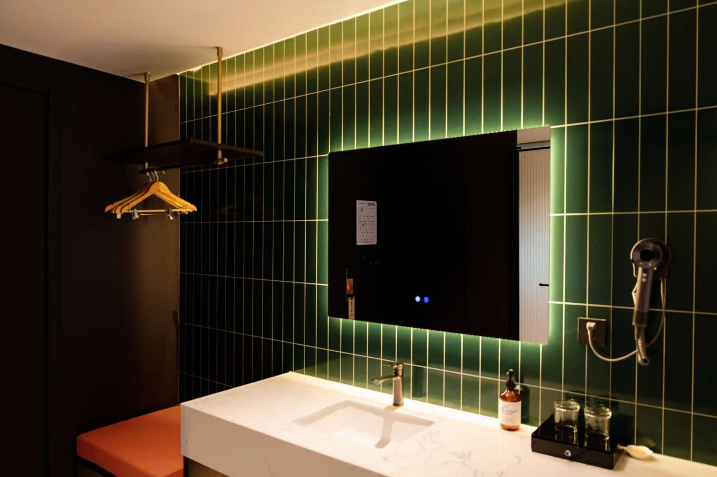 A bathroom with a white sink, a mirror, and a towel rack.