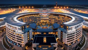 Um hotel moderno, circular, com vários andares e um pátio central.