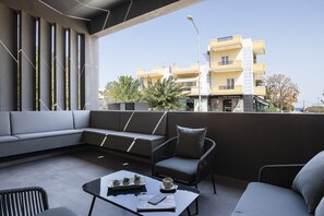 A modern outdoor seating area with a sofa, chairs, and a coffee table.