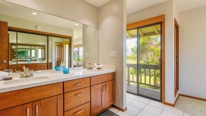 Une salle de bain moderne avec un grand miroir, deux vasques, des meubles en bois et une vue sur un balcon.
