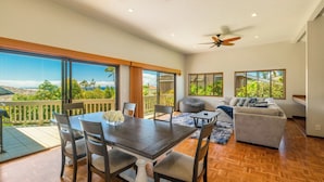 Un vaste espace de vie comprenant une table à manger, des chaises, un canapé et un balcon avec vue.