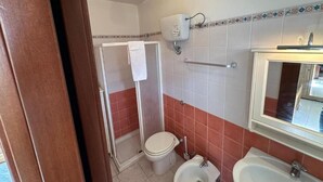 A bathroom with a toilet, bidet, sink, and shower. - Andromeda Rooms  in Otranto (Otranto)
