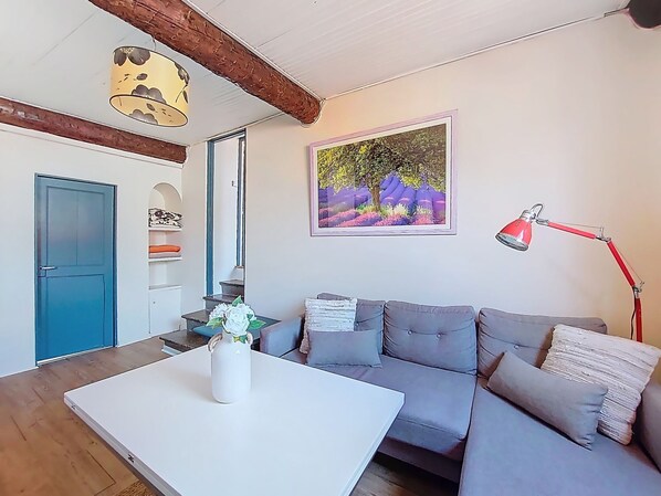 A living room with a white coffee table, grey sofa, and a red desk lamp. - Le Mascoïnat by Interhome (Nice)