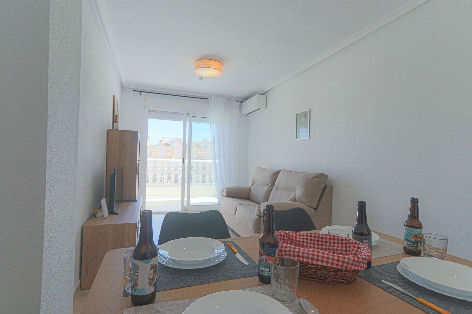 Un comedor con una mesa para dos, un sofá y un balcón con vistas.