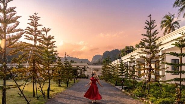 A pathway leading to a building with a red-roofed structure, surrounded by trees and a clear sky. - Tarn Villa Krabi (Krabi)